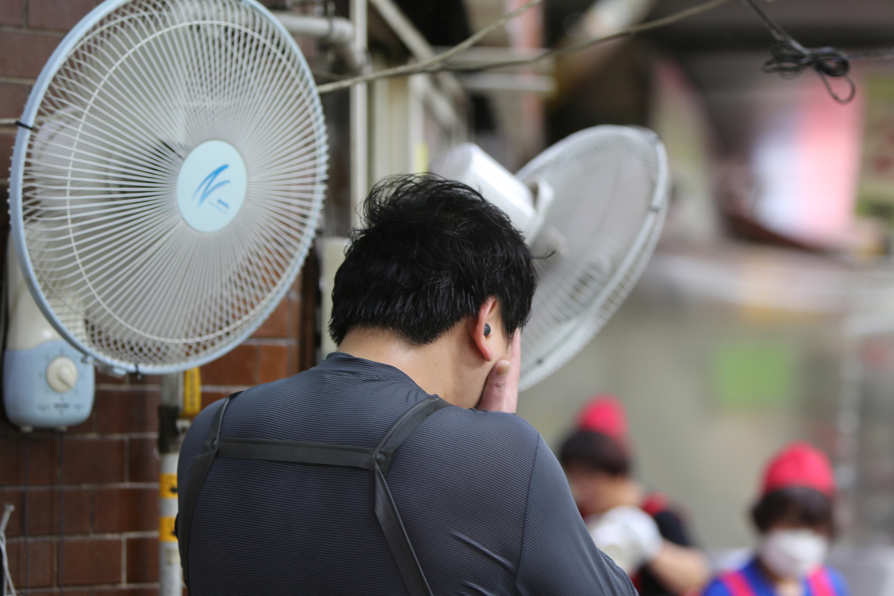 A vendor cools off by a fan in Malbau Market in Gwangju amid a heat wave on Aug. 1, 2024. (The Korea Herald DB)